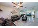 Open-concept living room with wood-look flooring, comfortable sofas, and a ceiling fan, seamlessly connecting to the dining area at 120 Read St, Tarpon Springs, FL 34689
