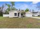 Inviting one-story home featuring a blue front door, well-manicured landscaping, and an attached garage at 12112 Shearwater Dr, New Port Richey, FL 34654
