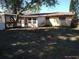 Expansive backyard featuring a trellis, screened-in porch, and lush surroundings at 12716 Mulberry Ln, Hudson, FL 34667