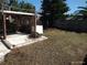 Wide backyard featuring a trellis-covered patio and a partially fenced perimeter at 12716 Mulberry Ln, Hudson, FL 34667