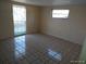 Bright bedroom with tile flooring, neutral walls, and a large window, creating a versatile space at 12716 Mulberry Ln, Hudson, FL 34667