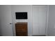 Bedroom with a chest of drawers, mounted TV, and closet space providing efficient storage at 12816 Wedgewood Way # D, Hudson, FL 34667