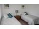 Bedroom with twin beds featuring comfortable bedding and a view from the large sunny window at 12816 Wedgewood Way # D, Hudson, FL 34667