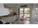 Kitchen area with white appliances, tile floor and access to outdoor deck at 12816 Wedgewood Way # D, Hudson, FL 34667