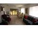 Spacious living room with tile floors and comfortable furniture by large screened windows at 12816 Wedgewood Way # D, Hudson, FL 34667