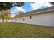 Wide backyard with green grass and views of the home's white exterior at 13186 Road Runner Ave, Weeki Wachee, FL 34614
