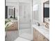 Luxury bathroom featuring double vanities, a glass-enclosed shower, and bright finishes at 13186 Road Runner Ave, Weeki Wachee, FL 34614