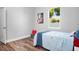 Well-lit bedroom with hardwood floors, vibrant art, and a bright window at 13186 Road Runner Ave, Weeki Wachee, FL 34614
