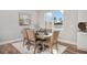 Elegant dining area with a wooden table, upholstered chairs, and a large window providing natural light, and modern decor at 13186 Road Runner Ave, Weeki Wachee, FL 34614