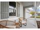 Inviting front porch with wicker furniture, providing a cozy outdoor seating area next to a large window at 13186 Road Runner Ave, Weeki Wachee, FL 34614