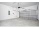 Spacious two car garage featuring a concrete floor, gray doors and white walls at 13186 Road Runner Ave, Weeki Wachee, FL 34614