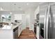 Well-lit kitchen featuring white cabinets, stainless steel appliances, and an island with a sink, offering ample counter space at 13186 Road Runner Ave, Weeki Wachee, FL 34614