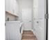 Bright laundry room featuring a stacked washer and dryer, white cabinets, and neutral walls at 13186 Road Runner Ave, Weeki Wachee, FL 34614