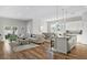 Spacious living area with hardwood floors, modern furniture, and a combined kitchen and dining area under recessed lighting at 13186 Road Runner Ave, Weeki Wachee, FL 34614
