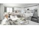 Open-concept living space with modern decor, a cozy sofa, a kitchen with an island, and stainless steel appliances at 13186 Road Runner Ave, Weeki Wachee, FL 34614