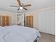 Bedroom with wood-look flooring, closet space, ceiling fan and access to the bathroom at 13604 Maria Dr, Hudson, FL 34667