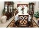 Spacious dining room featuring a table with eight chairs, china cabinets and an ornate rug at 14148 Finsbury Dr, Spring Hill, FL 34609