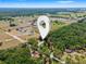 Wide aerial view showing a property's location amid lush trees, fields, and neighborhood homes at 16284 Sandusky St, Brooksville, FL 34604
