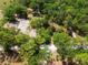 Aerial shot of the property with lush trees, a cleared building foundation, and winding driveway at 16284 Sandusky St, Brooksville, FL 34604