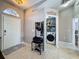 Well-lit entryway with tile floors, coat rack, and a view of the laundry room at 2165 Bolger Ave, Spring Hill, FL 34609