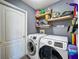 Modern laundry room with new washer and dryer, floating shelves, and gray walls at 2165 Bolger Ave, Spring Hill, FL 34609