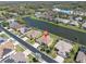 Stunning aerial perspective reveals a home on a lake with a manicured lawn and mature trees at 2330 Tarragon Ln, Trinity, FL 34655