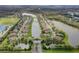 A picturesque aerial view showcases a neighborhood with a central lake, beautifully lined with single-Gathering homes and mature trees at 2330 Tarragon Ln, Trinity, FL 34655