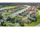 An aerial view of a well-maintained neighborhood with a central lake, lush landscaping, and charming single-Gathering homes at 2330 Tarragon Ln, Trinity, FL 34655