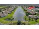 A stunning aerial view of a community built around a lake, featuring single-Gathering homes and mature landscaping at 2330 Tarragon Ln, Trinity, FL 34655