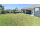 Well-maintained backyard with a covered patio, ample green space, and secure black metal fencing at 2330 Tarragon Ln, Trinity, FL 34655