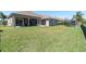 Spacious backyard featuring a lush green lawn and a covered patio perfect for outdoor entertaining at 2330 Tarragon Ln, Trinity, FL 34655
