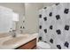 Bathroom featuring a sink, mirror, toilet, and a shower with black and white pineapple patterned shower curtain at 2330 Tarragon Ln, Trinity, FL 34655