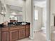 Bathroom vanity with dark wood cabinets, black countertop, and a view into the commode at 2330 Tarragon Ln, Trinity, FL 34655