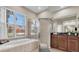 Bright bathroom featuring a soaking tub under a window, and a glass-enclosed shower at 2330 Tarragon Ln, Trinity, FL 34655