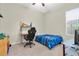 Carpeted bedroom with blue bedding, a ceiling fan, desk, and a computer at 2330 Tarragon Ln, Trinity, FL 34655