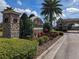 Magnolia Estates entrance featuring a stone monument, black iron gates, and lush landscaping at 2330 Tarragon Ln, Trinity, FL 34655