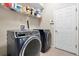 A laundry room is furnished with a washer, dryer and a wire shelf above it to store essentials at 2330 Tarragon Ln, Trinity, FL 34655