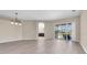 Open living area with laminate floors and glass sliding doors to an outdoor lanai overlooking the backyard at 2330 Tarragon Ln, Trinity, FL 34655