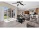 Bright living room with backyard view, ceiling fan, ample seating, and kitchen access, perfect for entertaining and Gathering gatherings at 2330 Tarragon Ln, Trinity, FL 34655