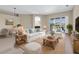 Cozy living room with comfortable seating, wood floors, and sliding glass doors to the backyard at 2330 Tarragon Ln, Trinity, FL 34655