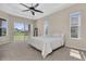 Tranquil main bedroom featuring a ceiling fan, carpeted floors, and view of the backyard and pond at 2330 Tarragon Ln, Trinity, FL 34655