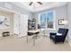 This home office is brightly lit with neutral walls, tan carpet and a window with a view of the neighborhood at 2330 Tarragon Ln, Trinity, FL 34655