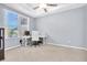 This home office is brightly lit with neutral walls, tan carpet and a window with a view of the neighborhood at 2330 Tarragon Ln, Trinity, FL 34655