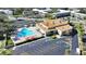 Aerial view of the community pool with a unique shape, surrounded by lounge chairs and umbrellas, near ample parking at 2400 Franciscan Dr # 8, Clearwater, FL 33763