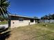 Exterior view of the home's rear showcasing a large backyard, white fence, and screened-in porch at 2630 63Rd S Ave, St Petersburg, FL 33712