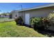 Side exterior view of the home with a door, lush landscaping, and green grass at 2630 63Rd S Ave, St Petersburg, FL 33712