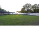 A large, open backyard with a white vinyl fence and trees at 29341 Rhodin Pl, Wesley Chapel, FL 33545