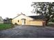 Exterior shot of home with attached garage and backyard access with a paved driveway at 29341 Rhodin Pl, Wesley Chapel, FL 33545