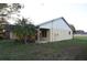 A home's exterior with a manicured lawn and mature palm tree at 29341 Rhodin Pl, Wesley Chapel, FL 33545