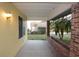 Covered front porch with stucco walls, brick accents, and a view of the surrounding landscape at 29341 Rhodin Pl, Wesley Chapel, FL 33545